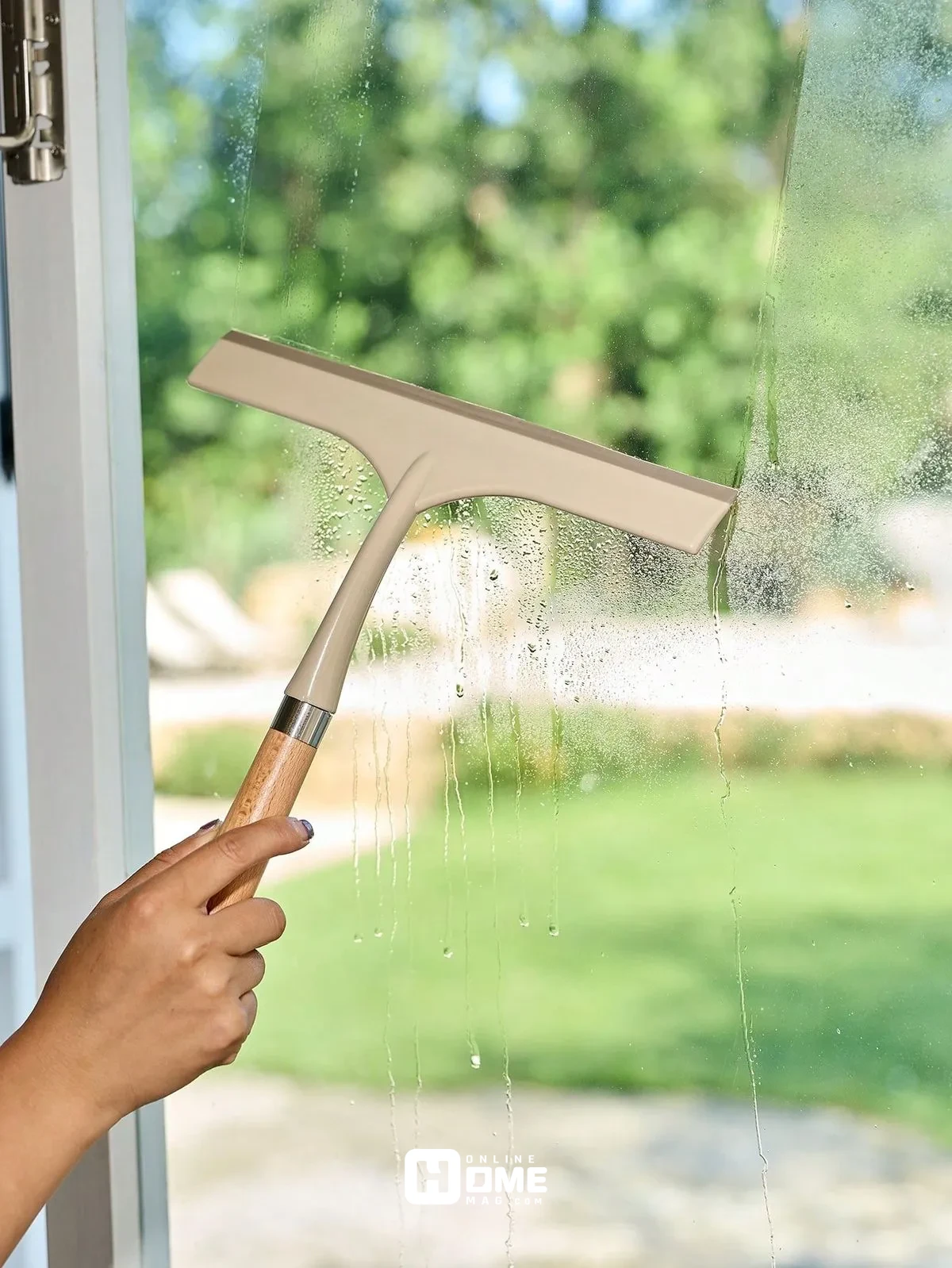 "A window scraper tool being used to remove paint, stickers, or tough residue from glass."