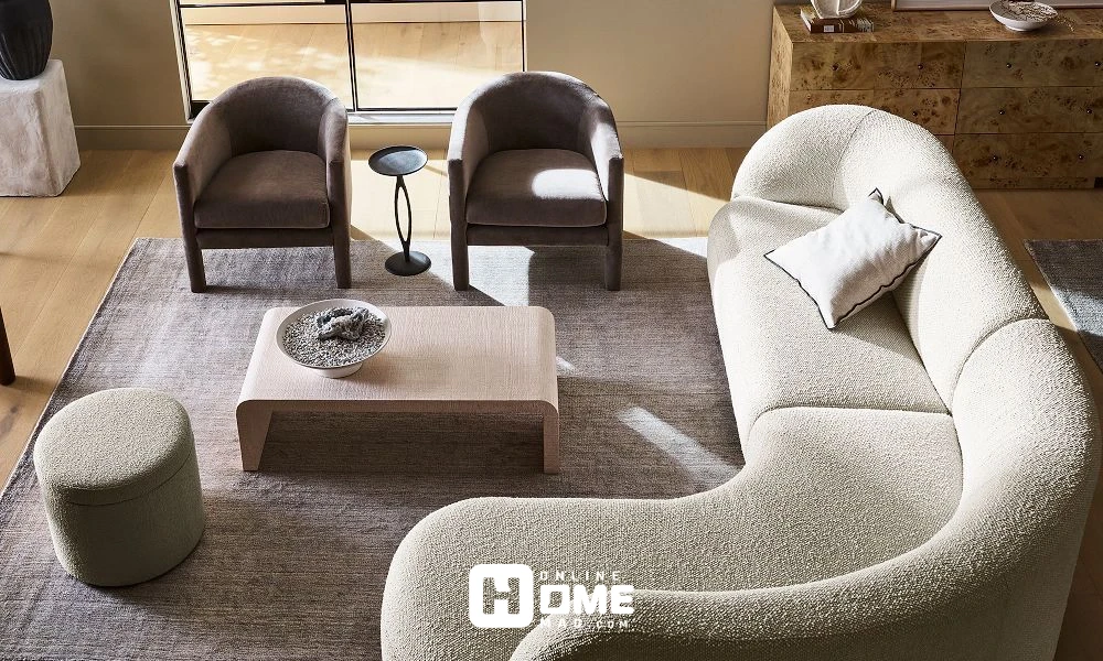 Modern sofa living room with curved sofa, armchairs, and minimalist decor in neutral tones.